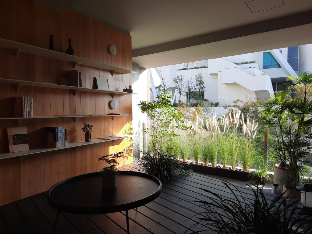 a room with a table on a wooden floor with plants at 珍友愛J Youai House -台南包棟民宿-2-8人包棟城市景觀住宿 in Tainan