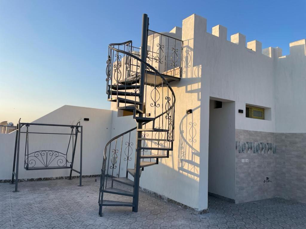 eine Wendeltreppe an der Seite eines Gebäudes in der Unterkunft Villamar Sea View in Hurghada