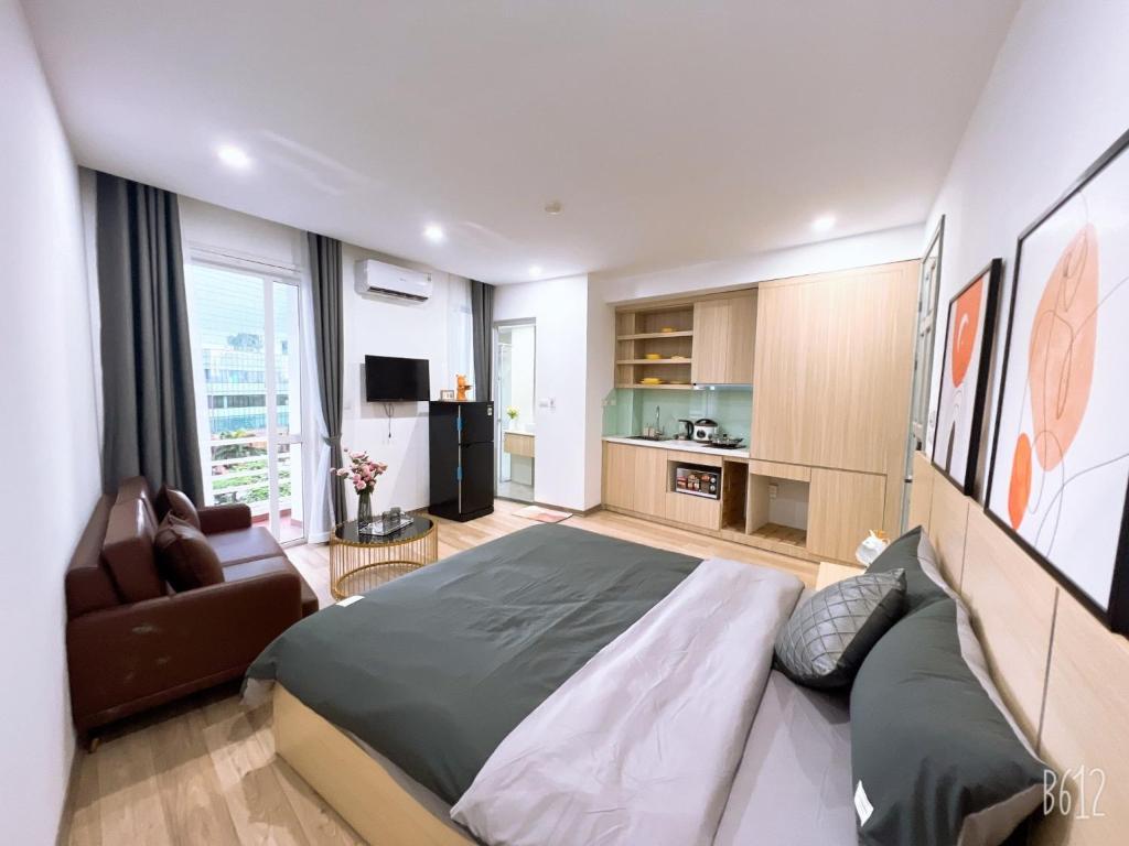 1 dormitorio con 1 cama grande y 1 sofá en Tglobal Apartment 204 Trần Duy Hưng en Hanói