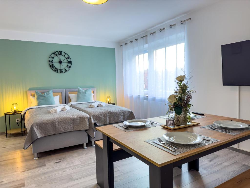 1 dormitorio con cama, mesa y reloj en ImmoStay #6 - Ferienhaus 4 Zimmer für 8 Personen, WiFi & Zentrum Bremen en Bremen