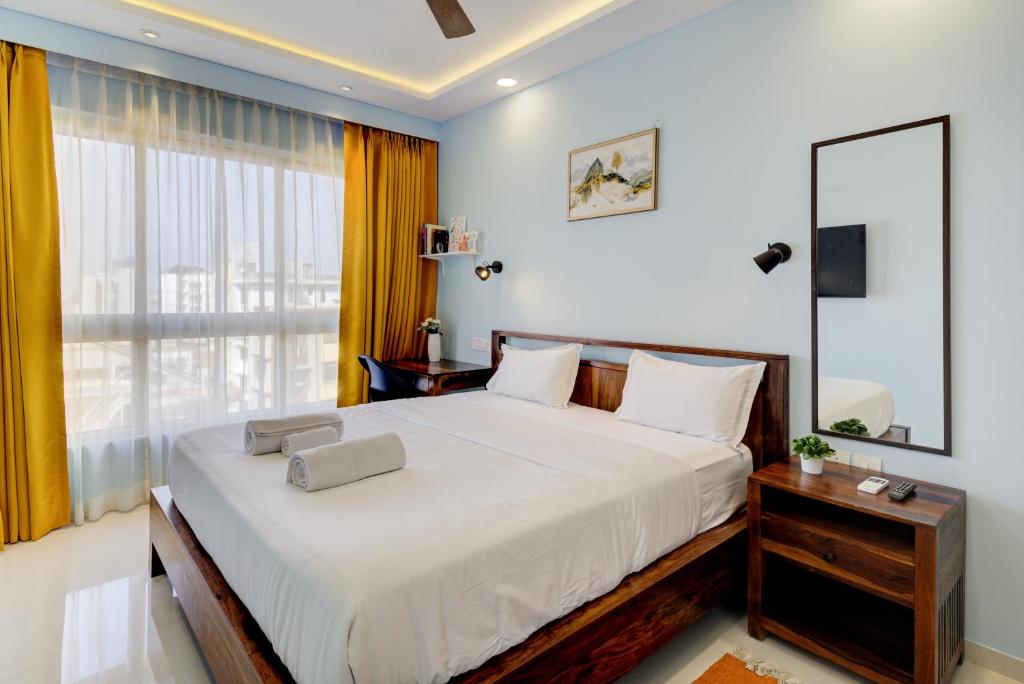 1 dormitorio con cama grande y ventana grande en Coral BnB Premium 2 BHK Apartment - 5 km from Dabolim Airport, en Vasco Da Gama
