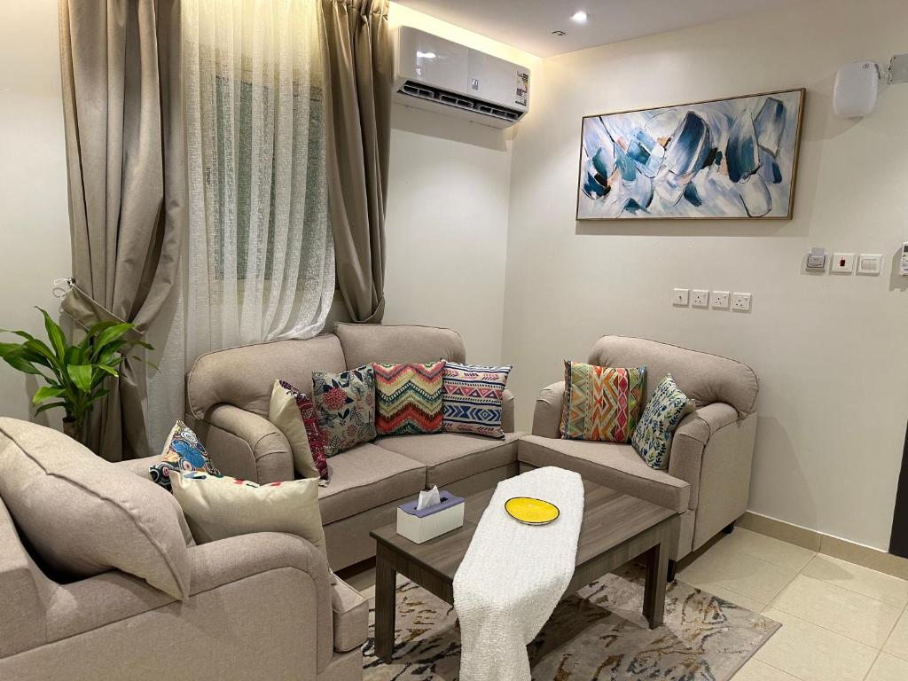 a living room with two couches and a table at استديو أنيق بدخول ذاتي in Al Kharj