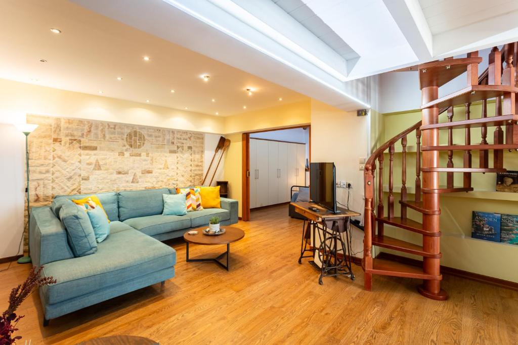 sala de estar con sofá azul y escalera en Lito's Central Gem - Cozy Dream Getaway, en Kalamata