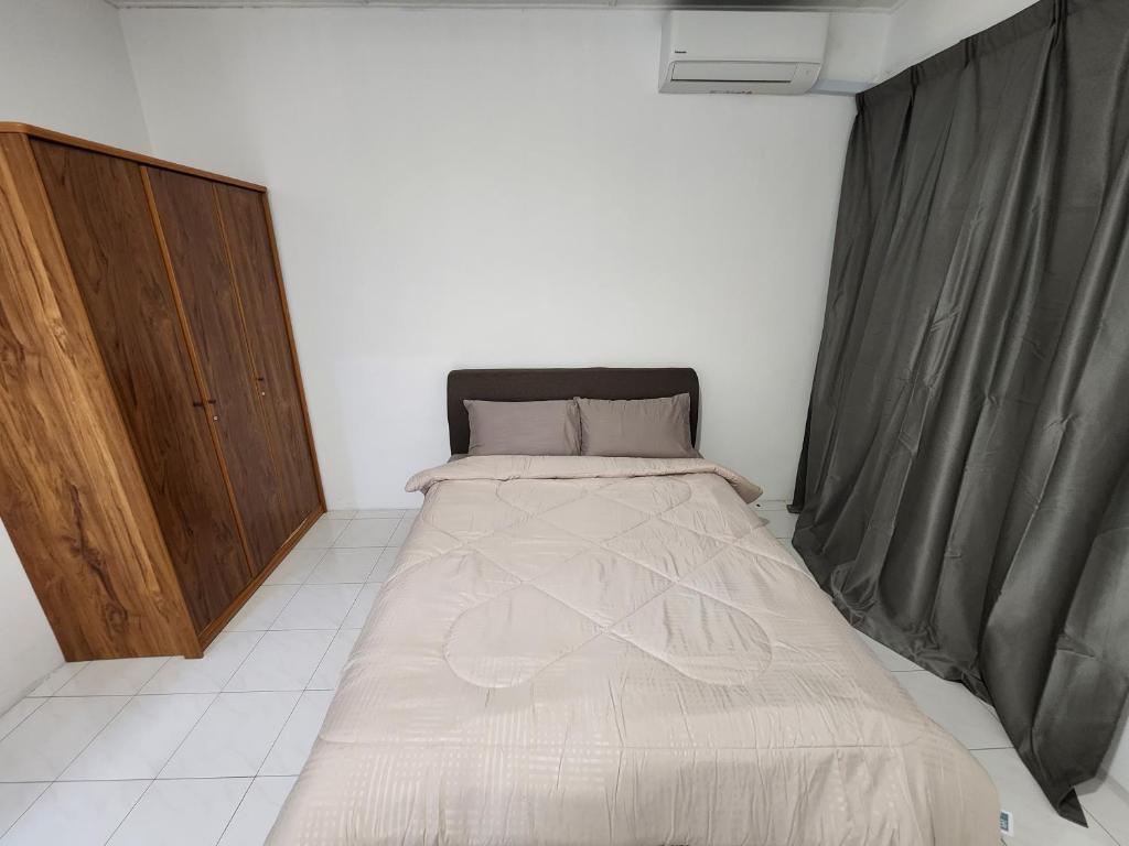 een kleine slaapkamer met een bed in een kamer bij DE ELITE KUCHING HOMESTAY in Kuching