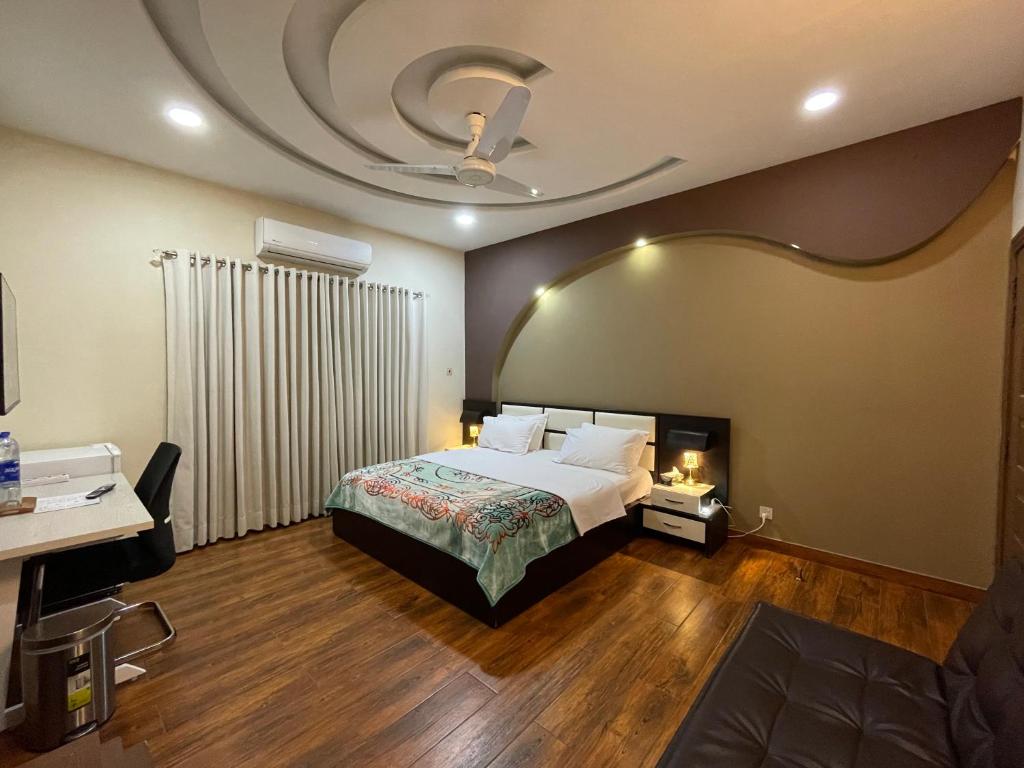 a bedroom with a bed and a ceiling at Alpha Guest House in Rawalpindi