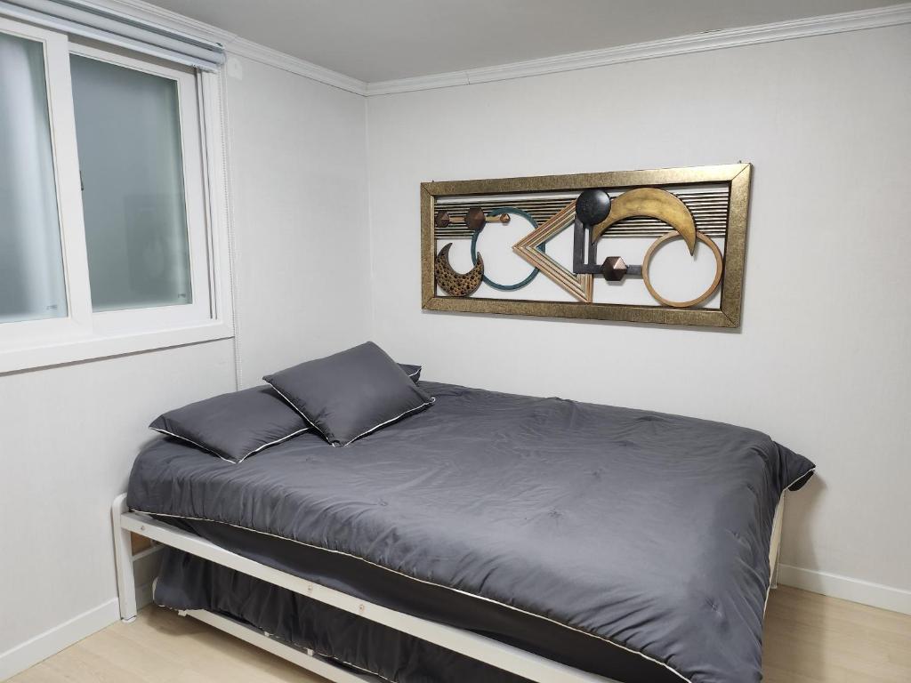 a bedroom with a bed with a picture on the wall at Brand New 2 Bedroom Apartment in Seoul