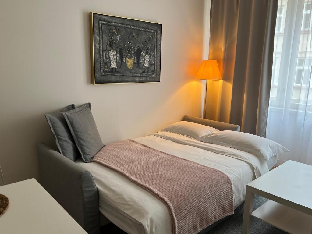 a bedroom with a bed and a picture on the wall at CITY CENTRUM CHARMING apartment in Prague
