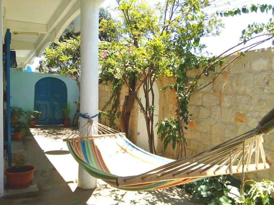 eine Hängematte auf einer Veranda eines Hauses in der Unterkunft La villa flamboyant in Mahajanga