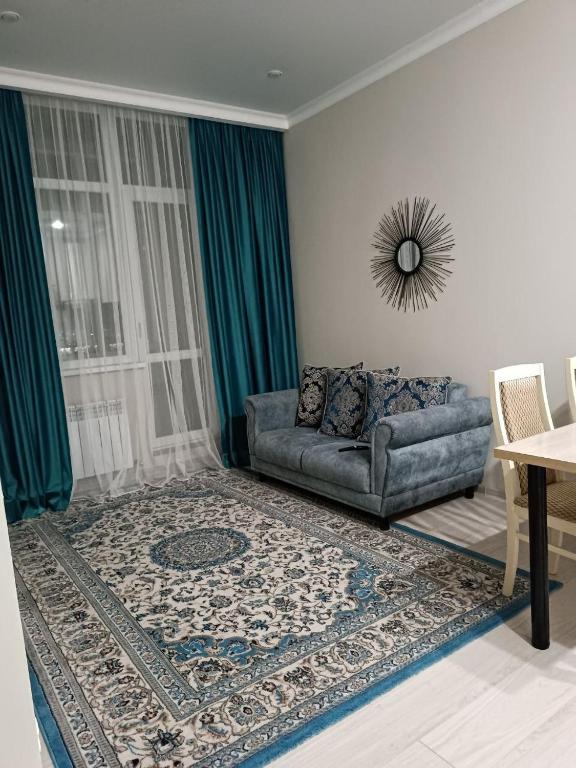 a living room with a couch and a window at Altyn Dala in Taldykolʼ