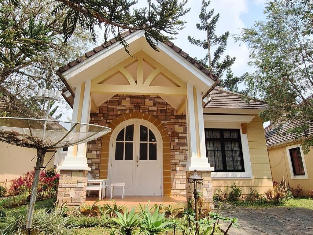una piccola casa in mattoni con una porta bianca di Villa Kota Bunga A11-07 a Cikundul
