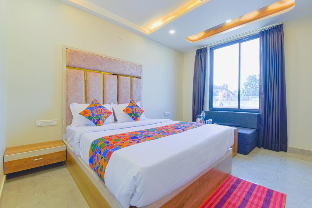 FabHotel Bohra International في جايبور: غرفة نوم بسرير ابيض كبير ونافذة