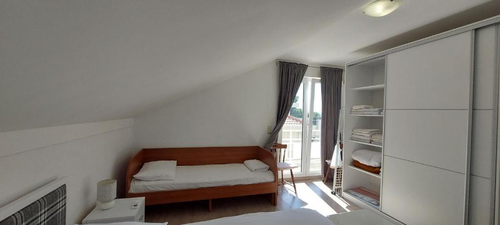 Habitación pequeña con cama y ventana en Apartman Figaro sa dva kupatila uz more i plažu s pogledom na Split, en Kaštela
