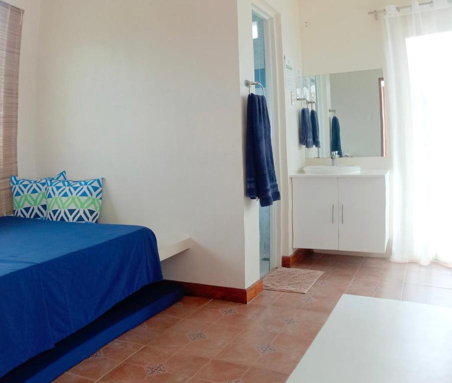 1 dormitorio con cama y baño con espejo. en Alon stay, en Baras