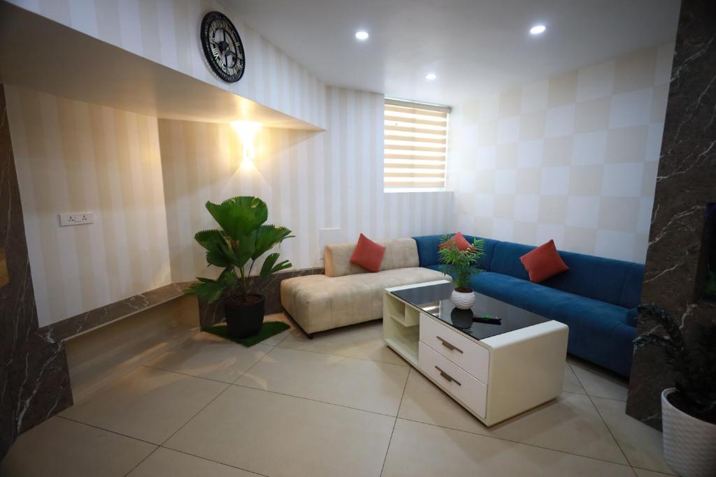 un soggiorno con divano blu e tavolo di Haksons Residency a Mananthavady