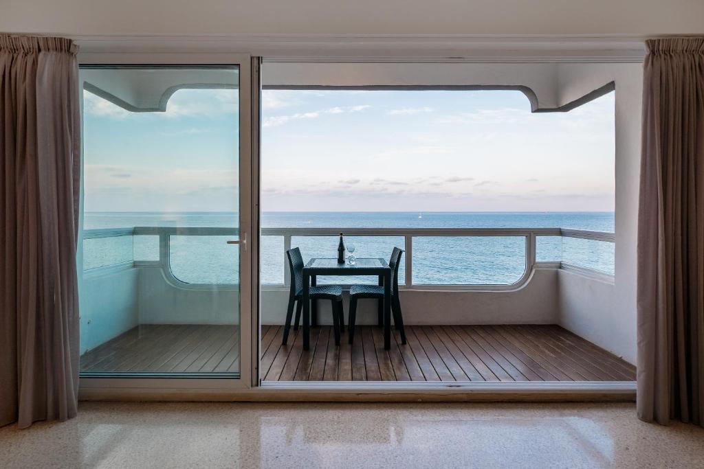 a balcony with a table and a view of the ocean at Sliema Seafront Apartment in Sliema