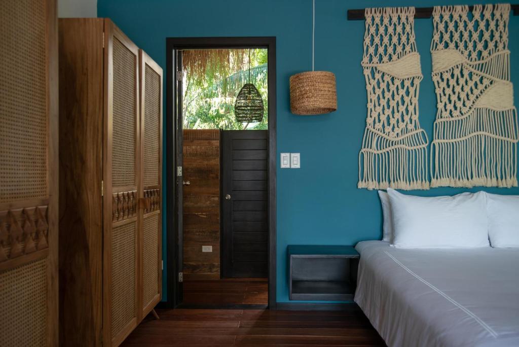 博卡奇卡的住宿－The Resort at Isla Palenque Member of the Cayuga Collection，一间卧室设有一张床和蓝色的墙壁