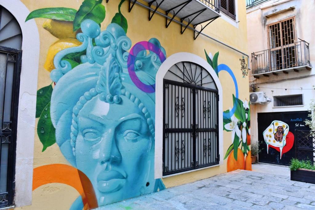 a wall with a painting of a face on it at Cortile dei Giusti - Combo Guesthouse in Palermo