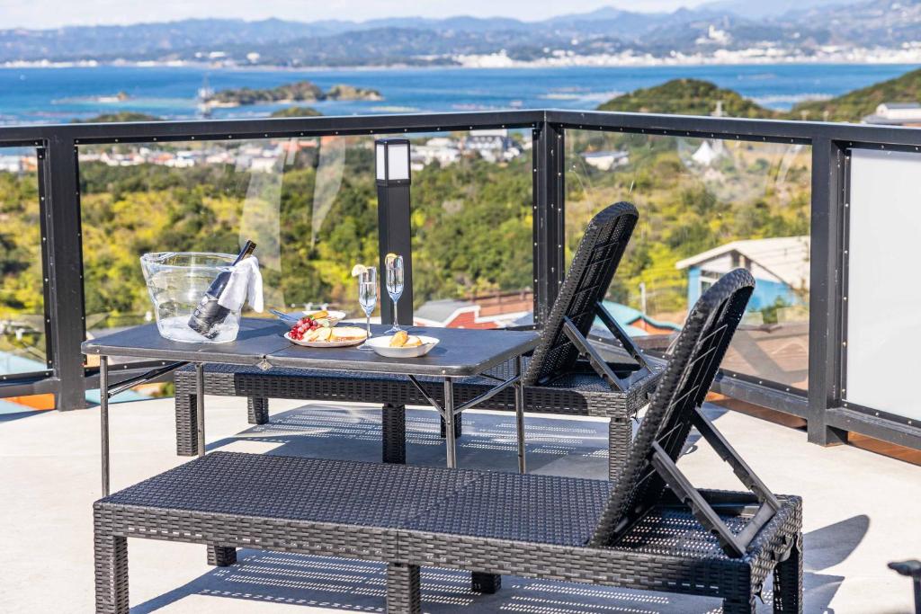einen Tisch und Stühle auf einem Balkon mit Aussicht in der Unterkunft 南紀白浜ビューポイント in Shirahama