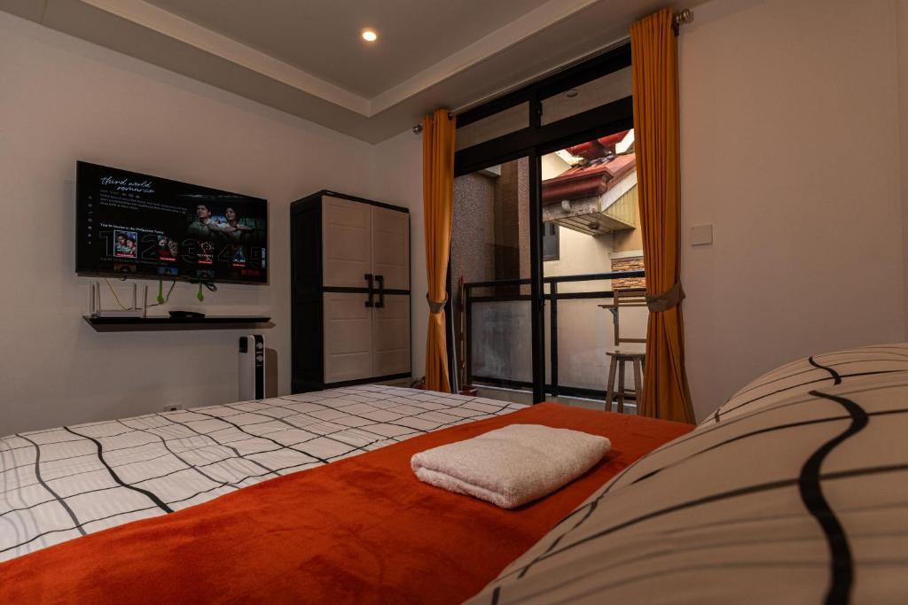 a bedroom with a bed with a tv on the wall at Johannes Condo in Baguio Megatower IV in Baguio