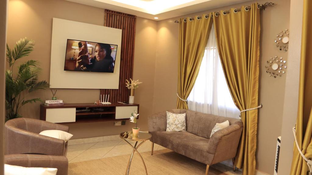 uma sala de estar com um sofá e uma cadeira em Premier Suites Kyanja em Kampala
