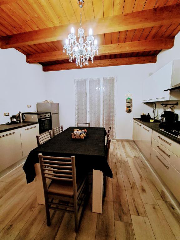 a dining room table with a chandelier in a kitchen at CASA FIORENTINI CESENATICO in Cesenatico