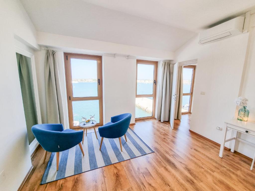 a living room with blue chairs and a table at Umag apartment center seafront seaview old town rentistra 2 in Umag