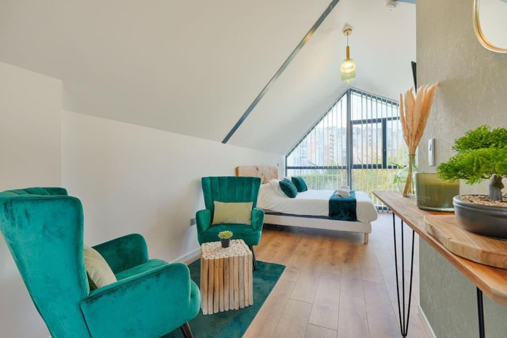 sala de estar con 2 sillas verdes y sofá en Welcome to the Verde, en Alfortville