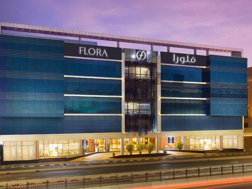 a rendering of a large building with a sign on it at Flora Inn Hotel Dubai Airport in Dubai