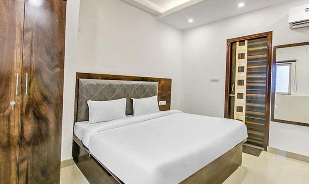 a bedroom with a large white bed in a room at FabExpress Mohan Vilas Residency in Dehradun