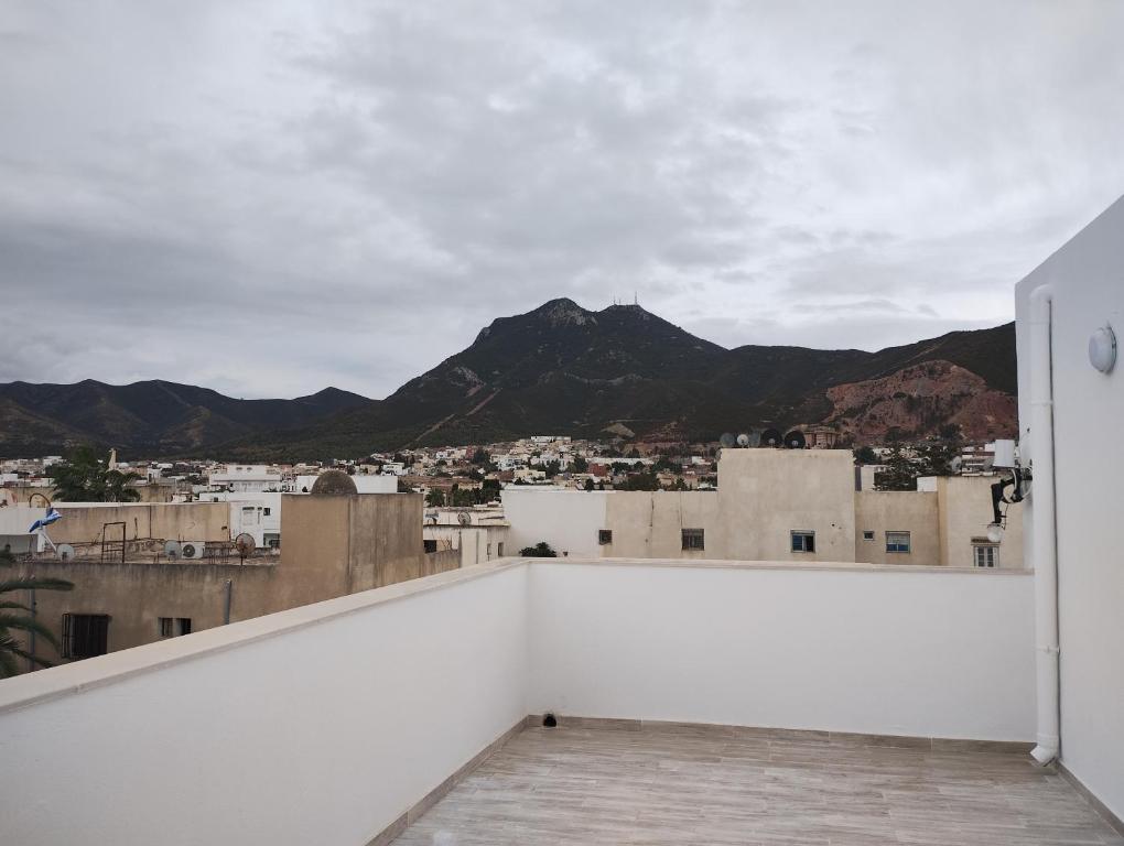 Hammam-Lif的住宿－Appartement Les Cyclamens Hammam Lif Tunisie，从一座背景为山脉的建筑的屋顶上可以欣赏到风景