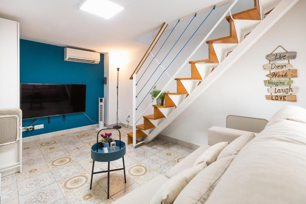 sala de estar con sofá blanco y escaleras en Casa El Palo, en Málaga