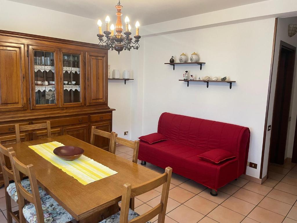un soggiorno con divano rosso e tavolo di CasaBruna ad Albiano