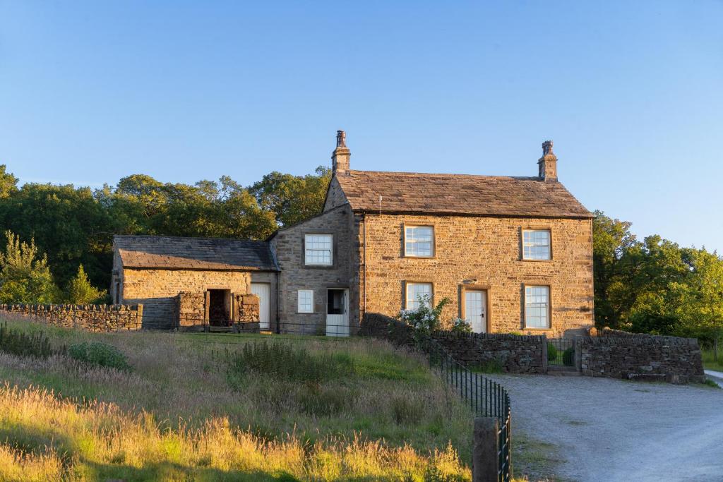 an old brick house on a grassy hill at Yellison at Broughton Sanctuary in Skipton