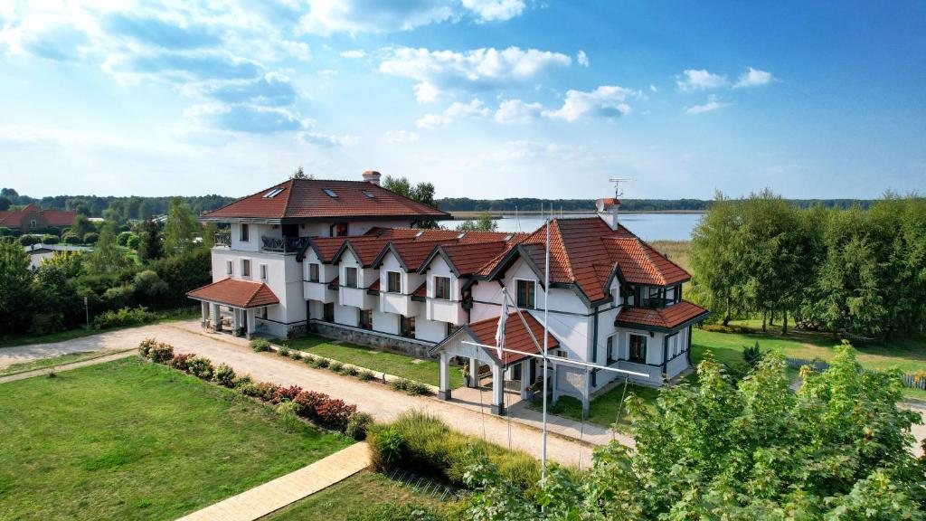 una gran casa blanca con techo rojo en Hotel Joseph Conrad en Pisz