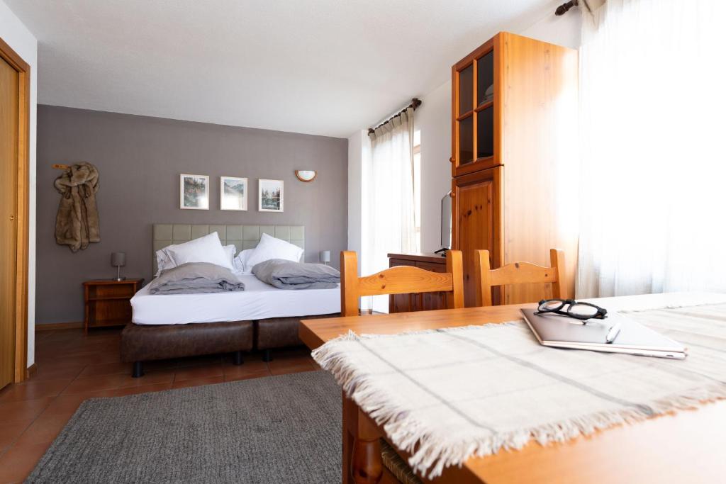um quarto com 2 camas, uma secretária e uma mesa em Chalet Ginepro em Santa Caterina di Valfurva