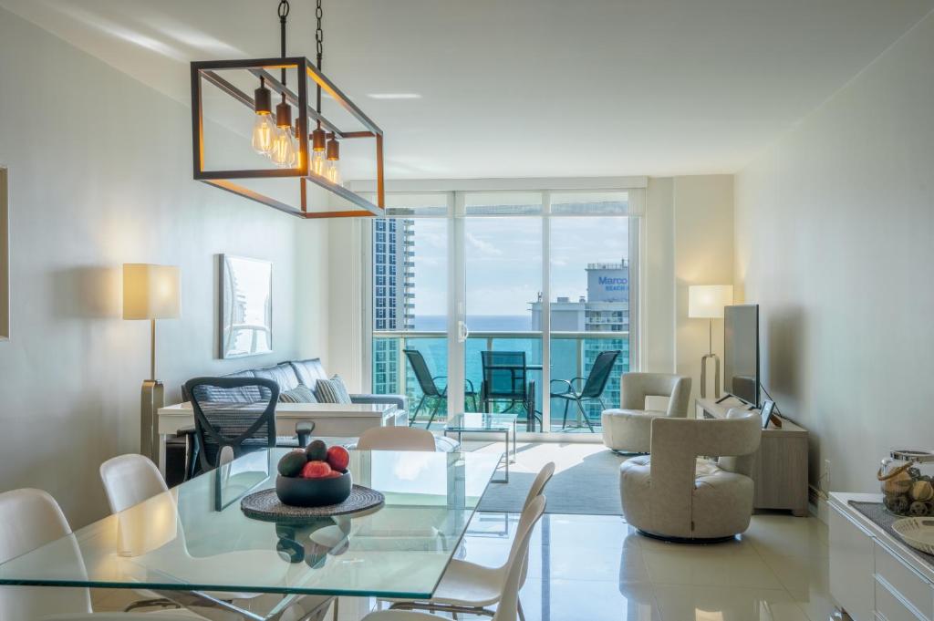 un soggiorno con tavolo e sedie in vetro di Ocean Reserve 14th floor - Wonderful Ocean View a Miami Beach