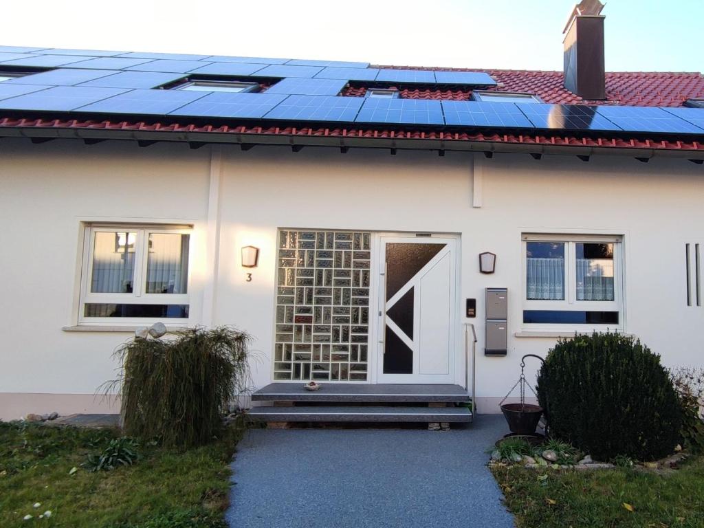 uma casa com muitos painéis solares no telhado em Ferienwohnung Mörike em Großengstingen