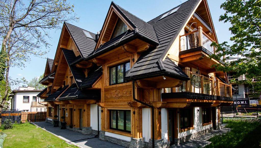 a wooden house with a black roof at Merynos- luksusowe apartamenty w centrum Zakopanego in Zakopane