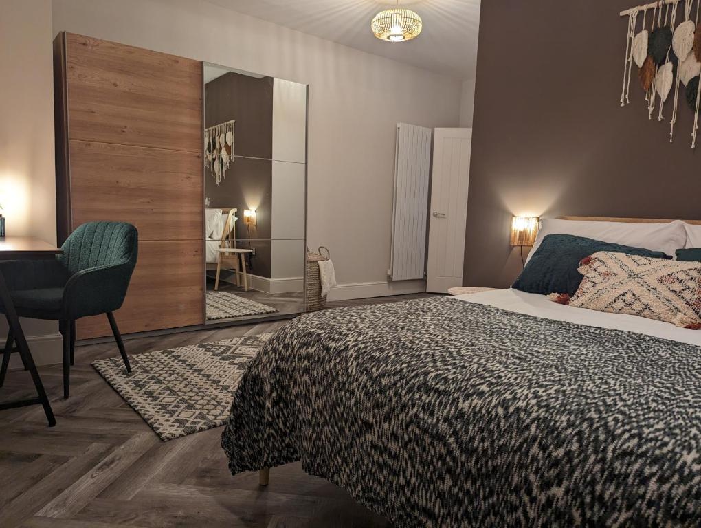a bedroom with a bed and a desk and a mirror at Wellington Circus in Nottingham