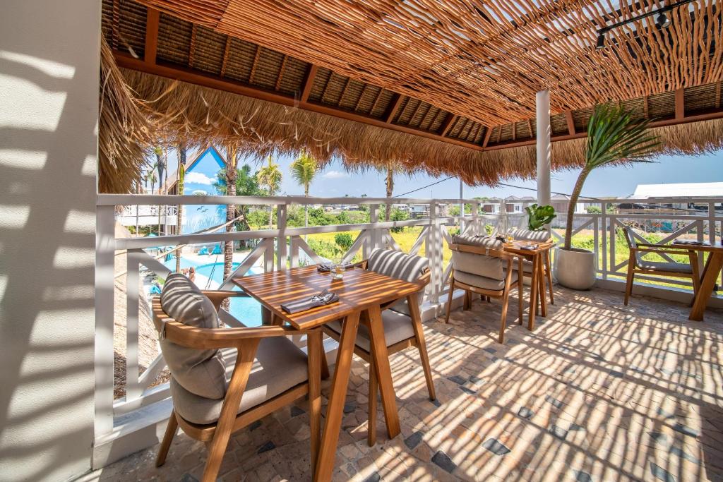 a restaurant with tables and chairs and a view of the ocean at IZE Canggu by LifestyleRetreats in Canggu