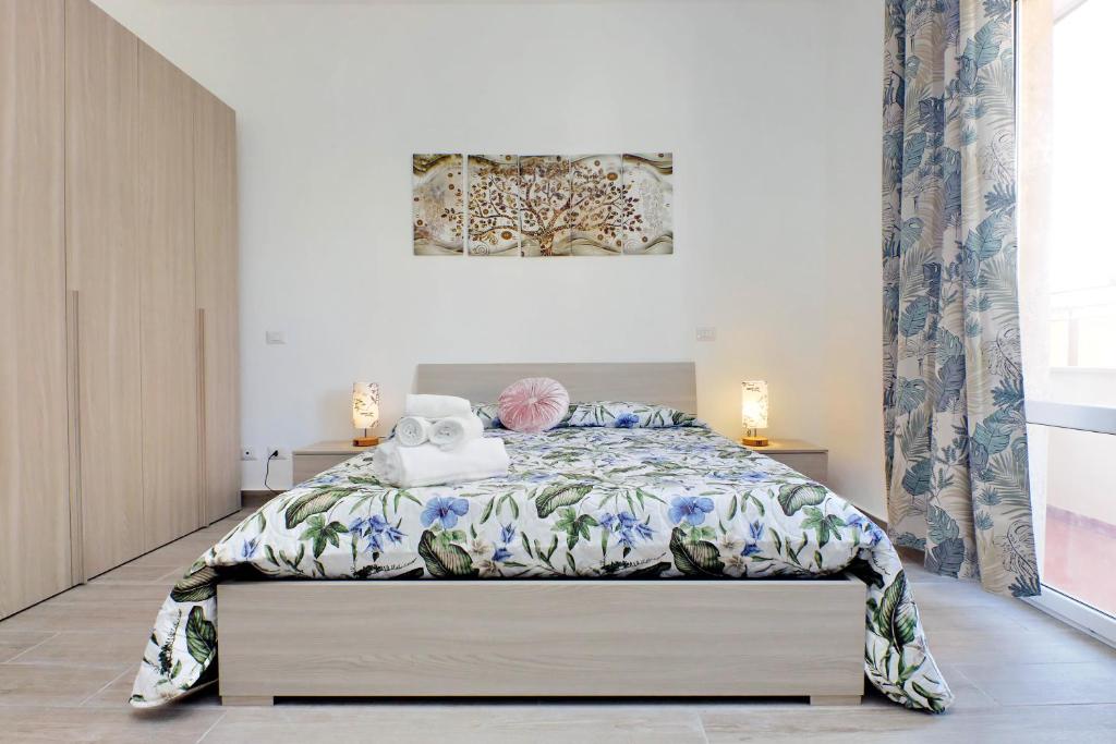 a bedroom with a bed with a floral bedspread at Tranquillità Centrale - Vicino Spiaggia e Aeroporto in Fiumicino