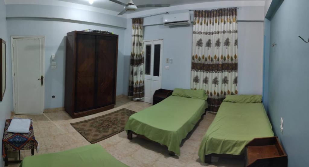 Pokój szpitalny z dwoma łóżkami i szafką w obiekcie ali habou w mieście Luksor