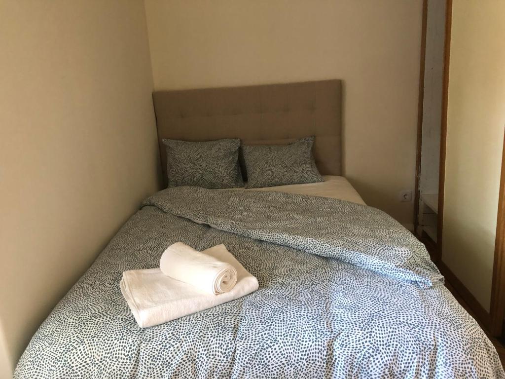 a bed with a white towel on top of it at Casa da Branca Gonta Colaço in Lisbon