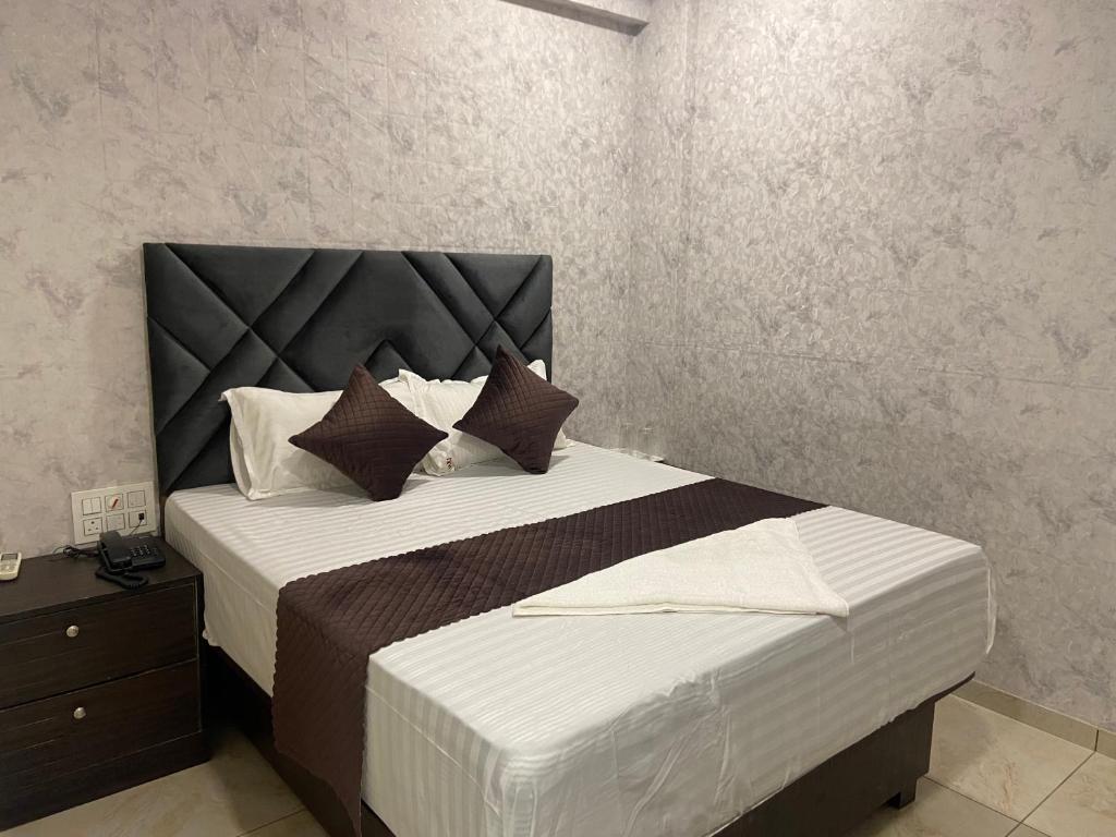 1 dormitorio con 1 cama grande y cabecero negro en Hotel Classio Inn - Near Kokilaben Hospital, Andheri West Mumbai, en Bombay