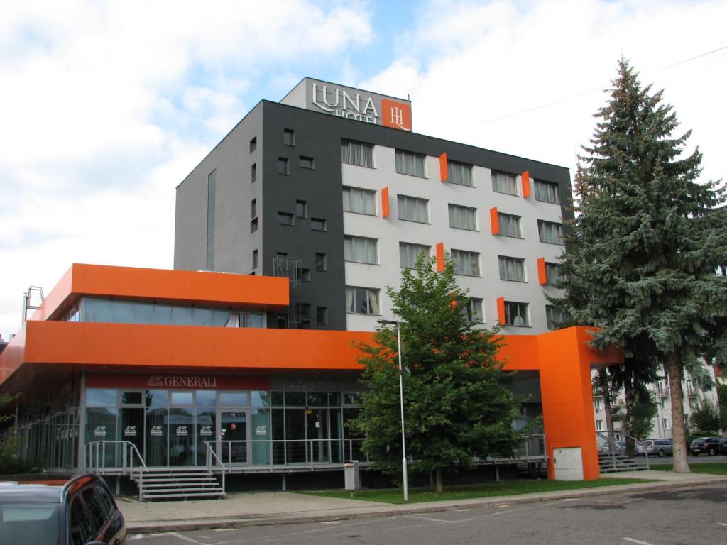 een hotel met een oranje en zwart gebouw bij Hotel Luna in Žiar nad Hronom