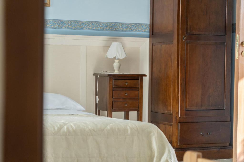 a bedroom with a bed and a dresser with a lamp at B&B Iris in Laterza
