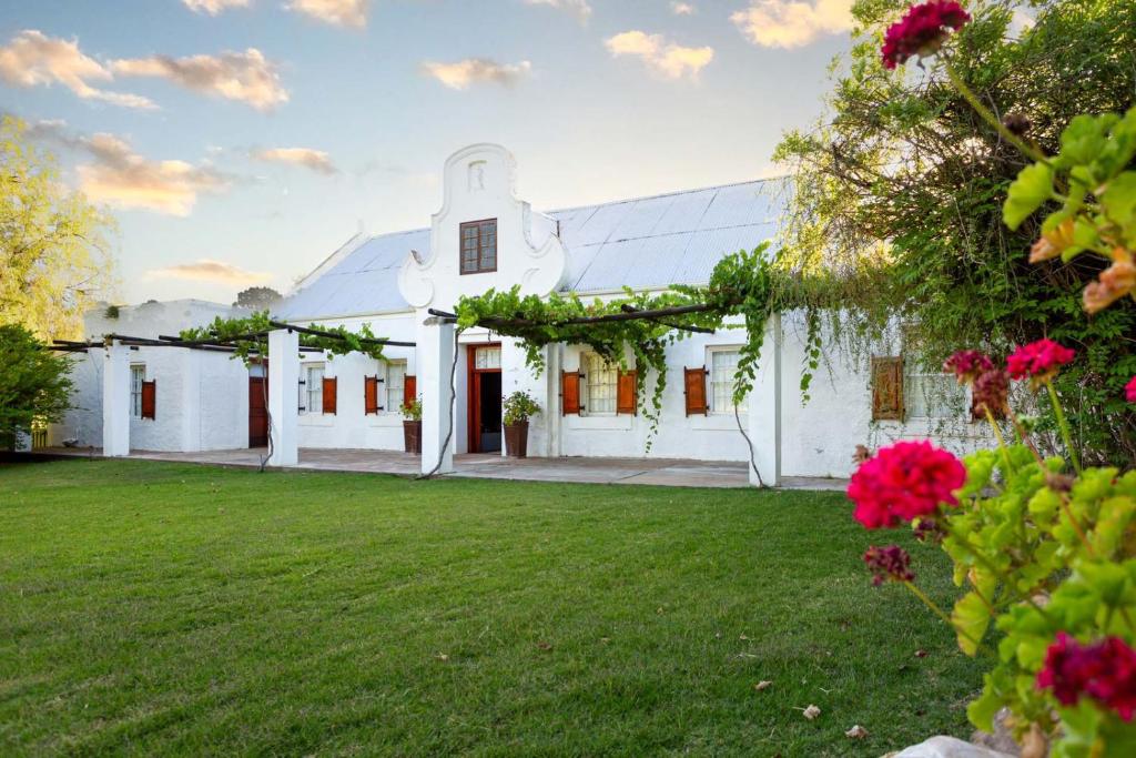 an exterior view of a white house with a yard at Bella de Karoo in Calitzdorp