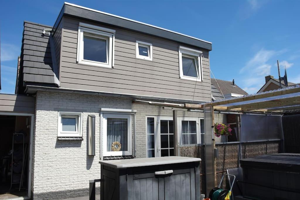 a house with a dog sitting in the window at Modern zomerhuis voor 4 personen in Wijk aan Zee