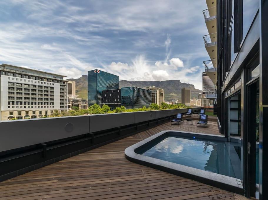 a balcony with a swimming pool on top of a building at Luxury City Living - 1 Bedroom with balcony in Cape Town