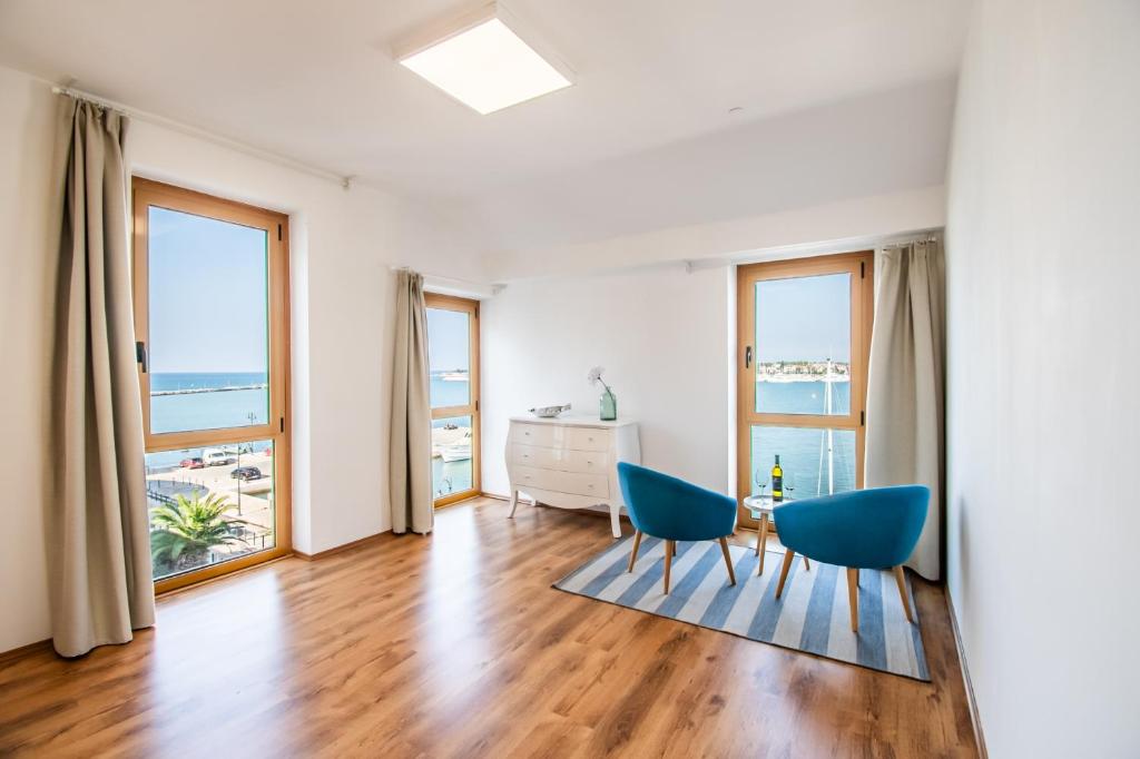 a living room with two chairs and a dresser at umag seafront seaview center apartment old town rentistra 3 in Umag